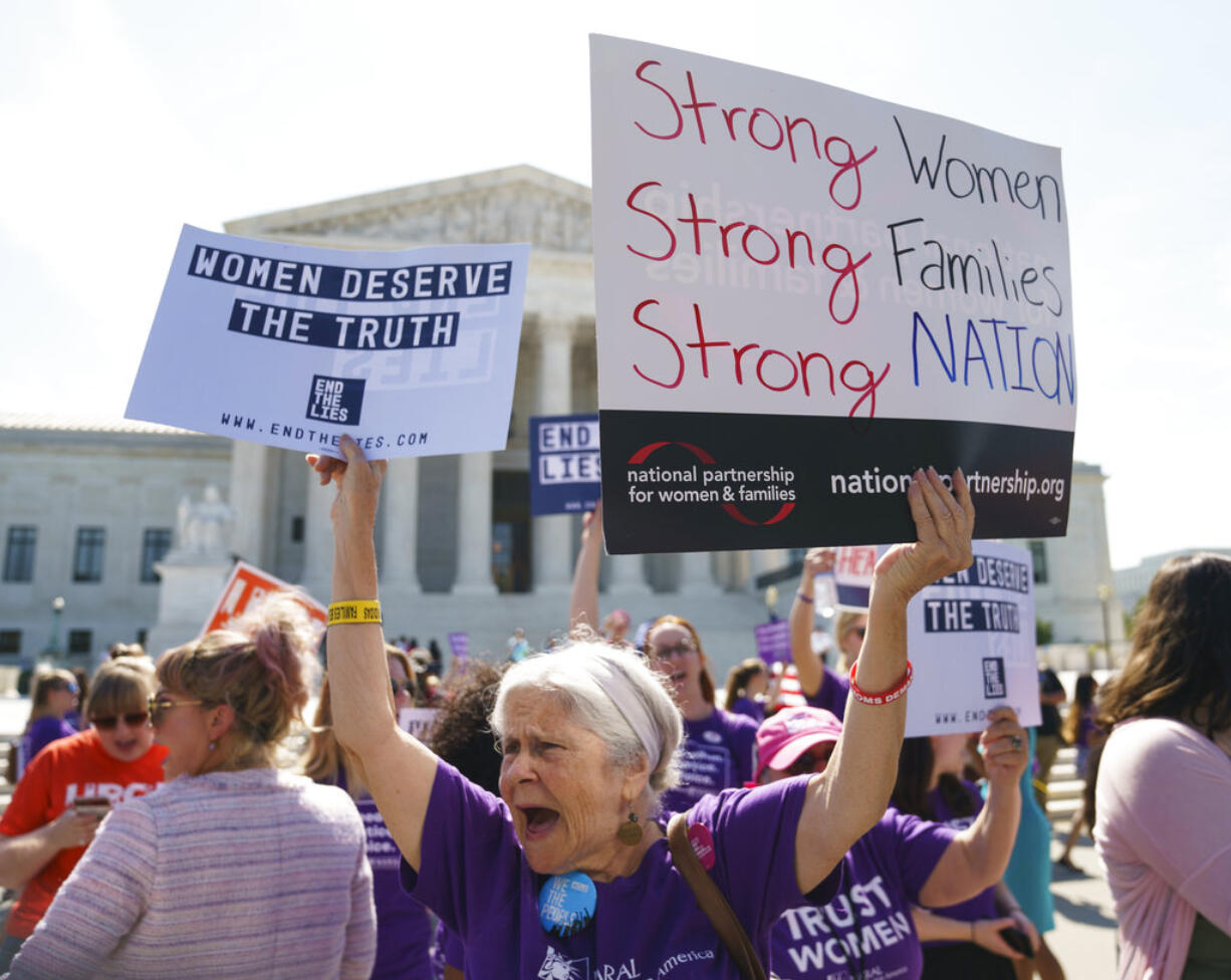 A woman protests outside the Supreme Court Building on Capitol Hill in in Washington, Tuesday, June 26, 2018.