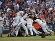 Oregon State players celebrate after they beat Arkansas 5-0 in Game 3 to win the NCAA College World Series baseball finals, Thursday, June 28, 2018, in Omaha, Neb.