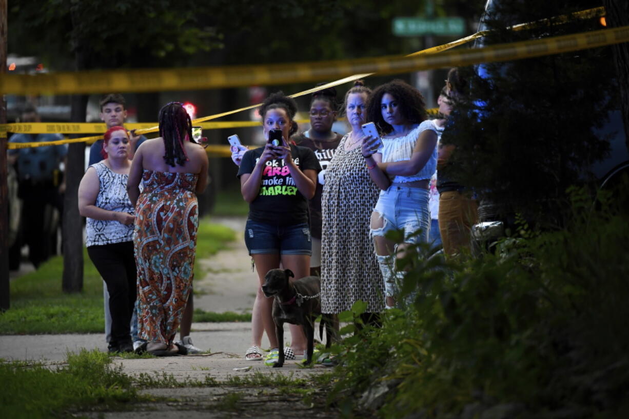 A crowd gathers near the scene of an officer-involved shooting which took place a few hours earlier Saturday in Minneapolis.