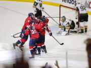 Teammates celebrate with Washington Capitals forward T.J. Oshie, center of the huddle, who scored a goal past Vegas Golden Knights goaltender Marc-Andre Fleury (29) during the first period in Game 4 of the NHL hockey Stanley Cup Final, Monday, June 4, 2018, in Washington.