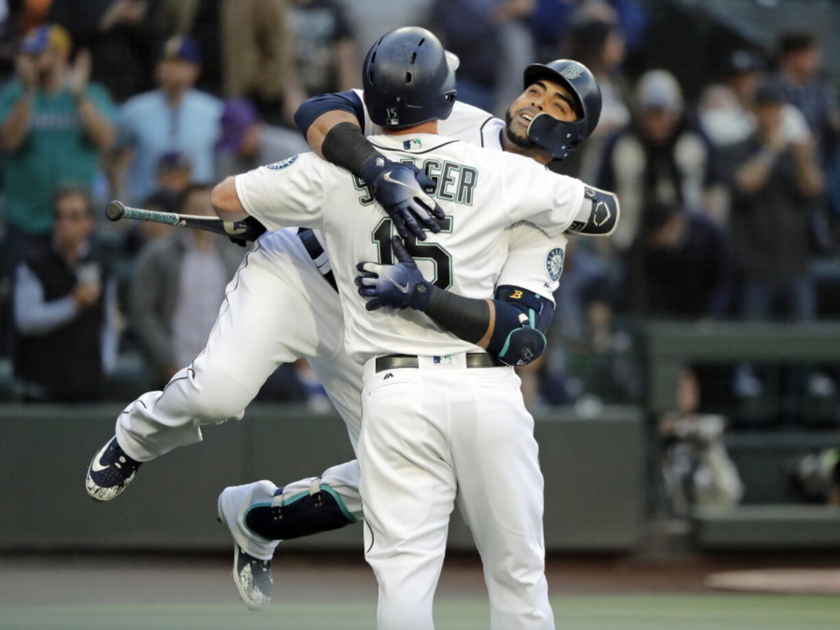 Seattle Mariners’ Nelson Cruz, right, hugs teammate Kyle Seager after Cruz hit a two-run home run to score Jean Segura during the first inning of a baseball game against the Los Angeles Angels, Monday, June 11, 2018, in Seattle. (AP Photo/Ted S.