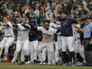 Seattle Mariners. including Jean Segura, center, who scored the game-winning run on a two-run walk-off home run by Mitch Haniger, wait for Haniger at the plate during the ninth inning of a baseball game against the Los Angeles Angels, Wednesday, June 13, 2018, in Seattle. The Mariners won 8-6. (AP Photo/Ted S.