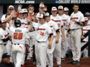 Oregon State’s Kyle Nobach (28) is greeted at the dugout after he scored against Mississippi State on a one-run single by Michael Gretler in the second inning of an NCAA College World Series baseball game in Omaha, Neb., Friday, June 22, 2018.