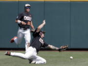 Oregon State shortstop Cadyn Grenier, foreground, leaps for but misses the ball hit for a single by North Carolina’s Ike Freeman in the third inning of an NCAA College World Series baseball game in Omaha, Neb., Saturday, June 16, 2018. Oregon State left fielder Jack Anderson (29) looks on.