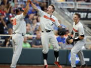 Oregon State’s Tyler Malone (7) celebrates with Adley Rutschman (35) and Michael Attalah (40) after hitting a three-run home run against Mississippi State in the third inning. The blast capped a five-run inning that led the Beavers back to the College World Series finals to face Arkansas.