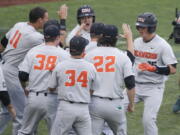 Oregon State’s Adley Rutschman, right, is congratulated near the dugout after his solo home run against North Carolina during the first inning of an NCAA College World Series baseball elimination game in Omaha, Neb., Wednesday, June 20, 2018.