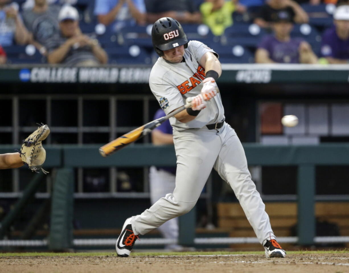 Oregon State designated hitter Kyle Nobach (28) hits a three-run home run in the seventh inning of an NCAA College World Series baseball elimination game against Washington in Omaha, Neb., Monday, June 18, 2018. Oregon State won 14-5.