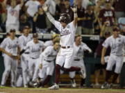 Mississippi State’s Hunter Stovall, center, celebrates as he runs to home plate for the winning run against Washington on a single by Luke Alexander in the ninth inning of an NCAA College World Series baseball game in Omaha, Neb., Saturday, June 16, 2018.