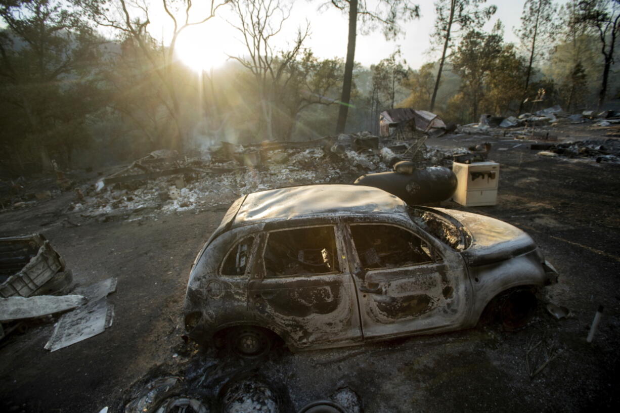 A vehicle scorched by a wildfire rests in a clearing on Wolf Creek Road near Clearlake Oaks, Calif., Sunday, June 24, 2018. Wind-driven wildfires destroyed buildings and threatened hundreds of others Sunday as they raced across dry brush in rural Northern California.