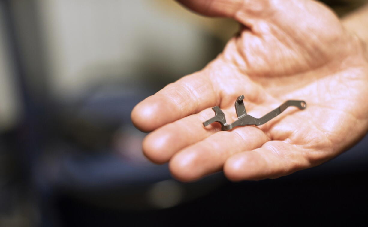 In this April 25, 2018, photo, Gary Ramey, owner and founder of Honor Defense, a gunmaker in Gainesville, Ga., holds a part from one of the company’s firearms. Ramey and others in the gun industry are finding corporate America distancing itself from gunmakers and gun dealers, discontinuing discounts or refusing business.