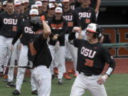 Oregon State’s Adley Rutschman (35) celebrates with Micahel Gretler (10) after hitting a solo home run in the first inning against Minnesota on Friday in Corvallis, Ore.