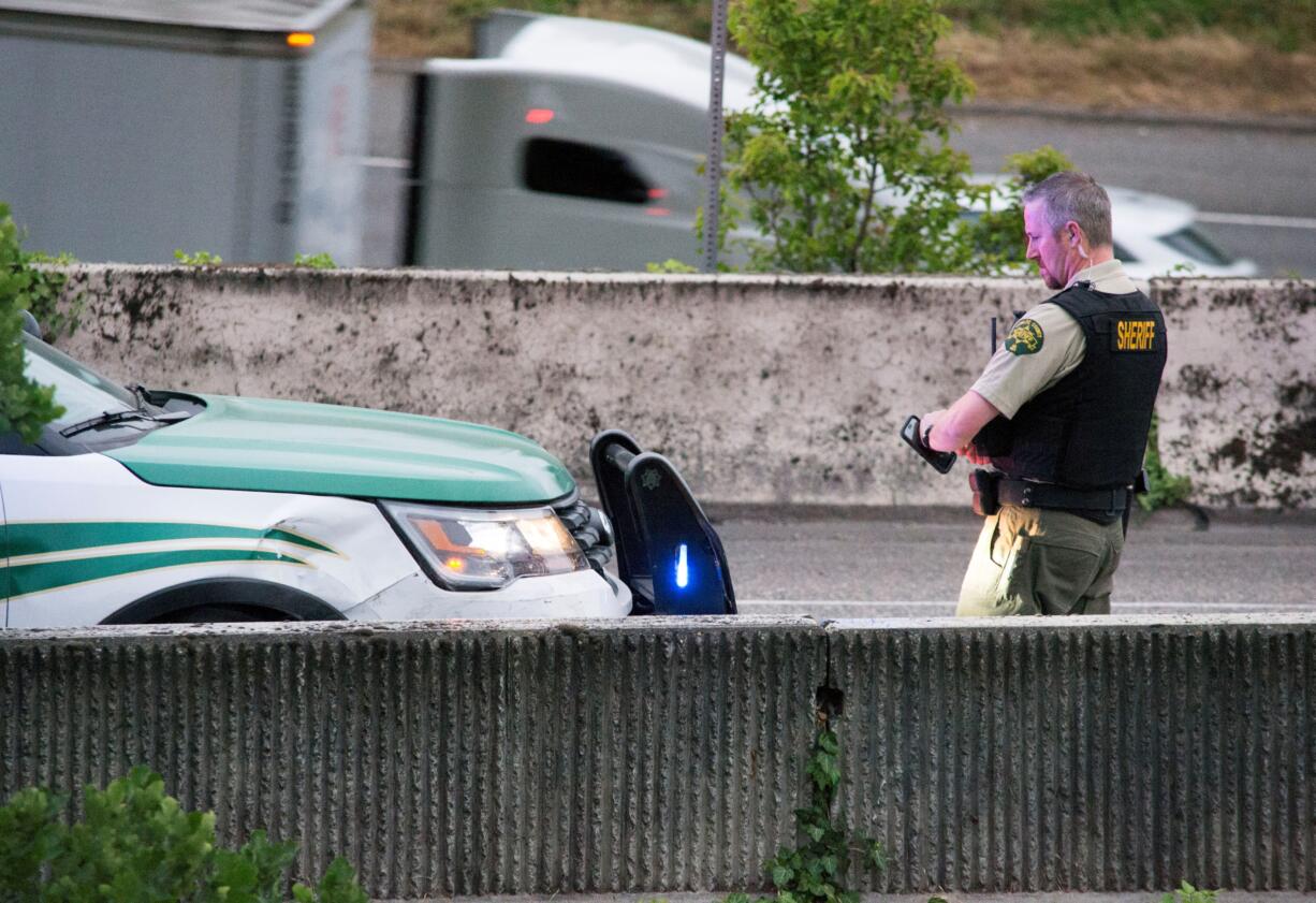 A Cowlitz County deputy sheriff inspects a vehicle at the conclusion of a pursuit Thursday night that started on Interstate 5 in the neighboring county and ended in downtown Vancouver. Deputies used the so-call PIT maneuver to stop the female driver.