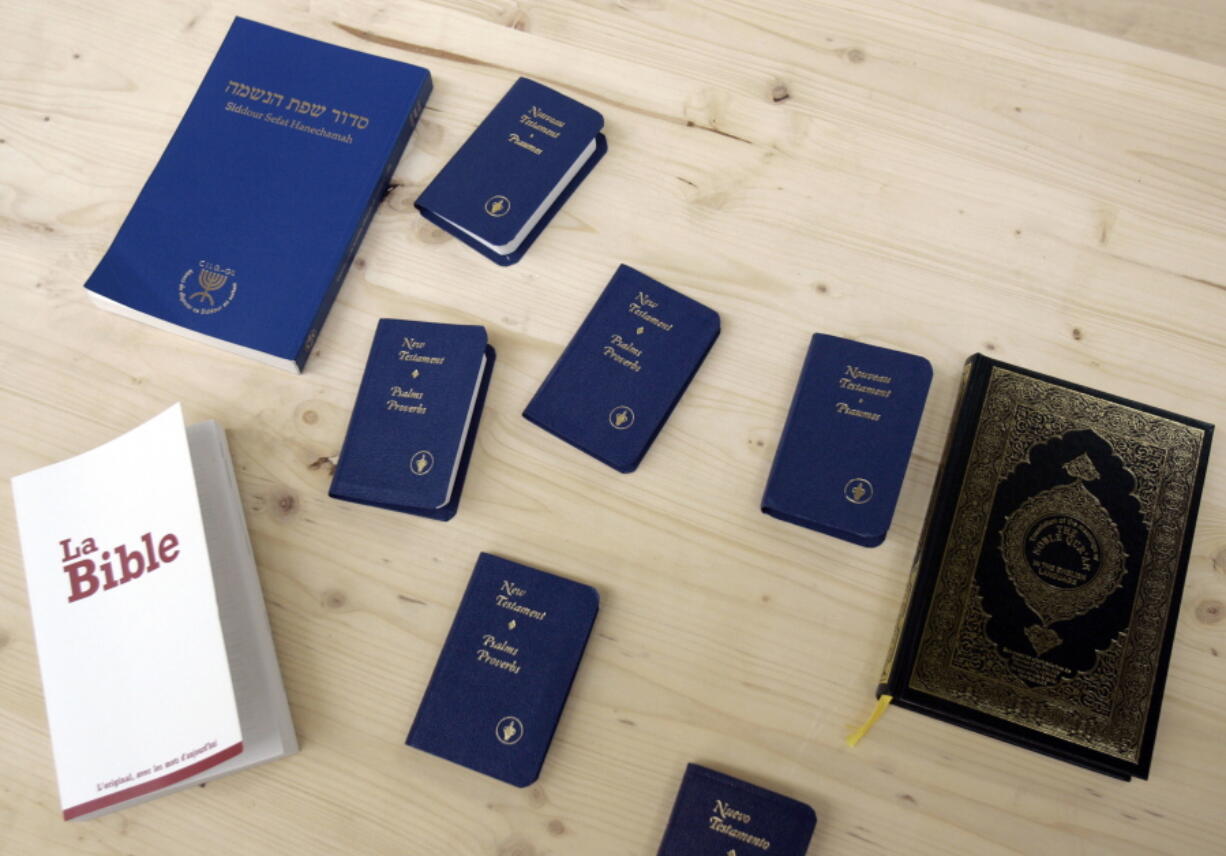 FILE - In this Thursday, June 5, 2008 file photo, books from the three monotheistic religions, clockwise from bottom left, the Bible, a Jewish Siddour, several copies of the New Testament and the Quran are seen on a table at a prison built for potential inmates at the Palexpo in Geneva, Switzerland. A new study suggests Christians in western Europe are less accepting of immigrants and non-Christians than people without religious affiliations.