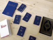 FILE - In this Thursday, June 5, 2008 file photo, books from the three monotheistic religions, clockwise from bottom left, the Bible, a Jewish Siddour, several copies of the New Testament and the Quran are seen on a table at a prison built for potential inmates at the Palexpo in Geneva, Switzerland. A new study suggests Christians in western Europe are less accepting of immigrants and non-Christians than people without religious affiliations.