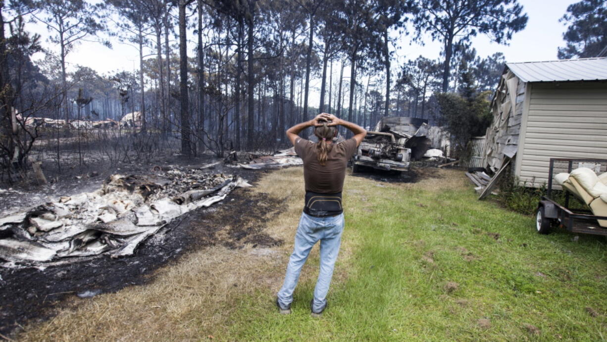 Faron Bryant looks over his property after wildfires swept through his neighborhood on Ridge Road in Eastpoint, Fla. Bryant’s home only lost its siding, but his workshop, a truck and boat were destroyed. Adam Putnam, Florida’s agriculture commissioner, said Wednesday that a controlled burn by state contractors sparked a wildfire that destroyed 36 homes and burned more than 800 acres.