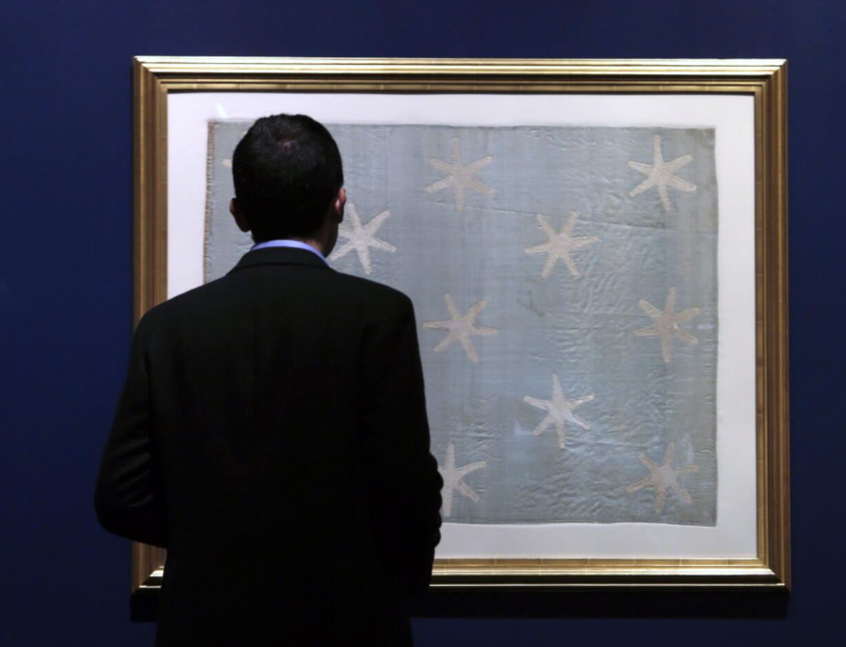 Assistant curator Matthew Skic looks the newly-hung Commander-in-Chief’s Standard on Wednesday at the Museum of the American Revolution in Philadelphia. The faded and fragile blue silk flag marked General George Washington’s presence on the battlefield during the Revolutionary War. The museum is bringing the flag out of its archives for public viewing on Thursday, June 14, Flag Day, until Sunday. Its appearance at the museum is the flag’s first public display in Philadelphia since the war.