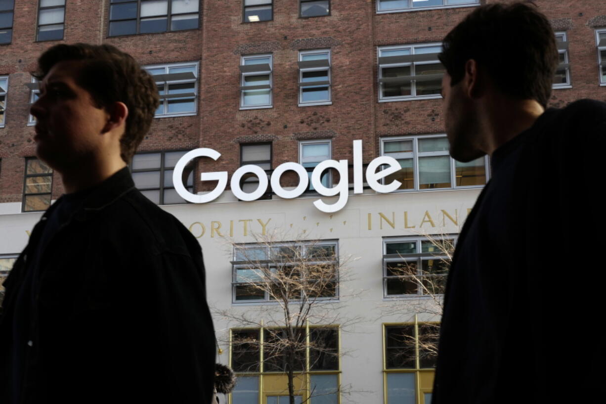 People walk by Google offices in New York.