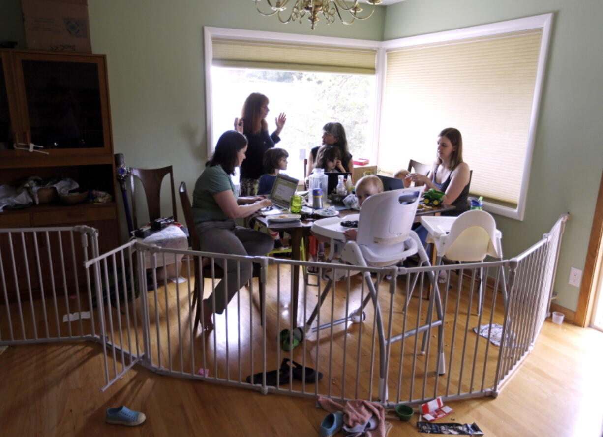 A small group of stay-at-home mothers, with children at their sides, work Wednesday to organize an immigration rally in Portland. From left they are Kate Sharaf, Lisa Carol Stiller, Erin Conroy and Caely Barrett.