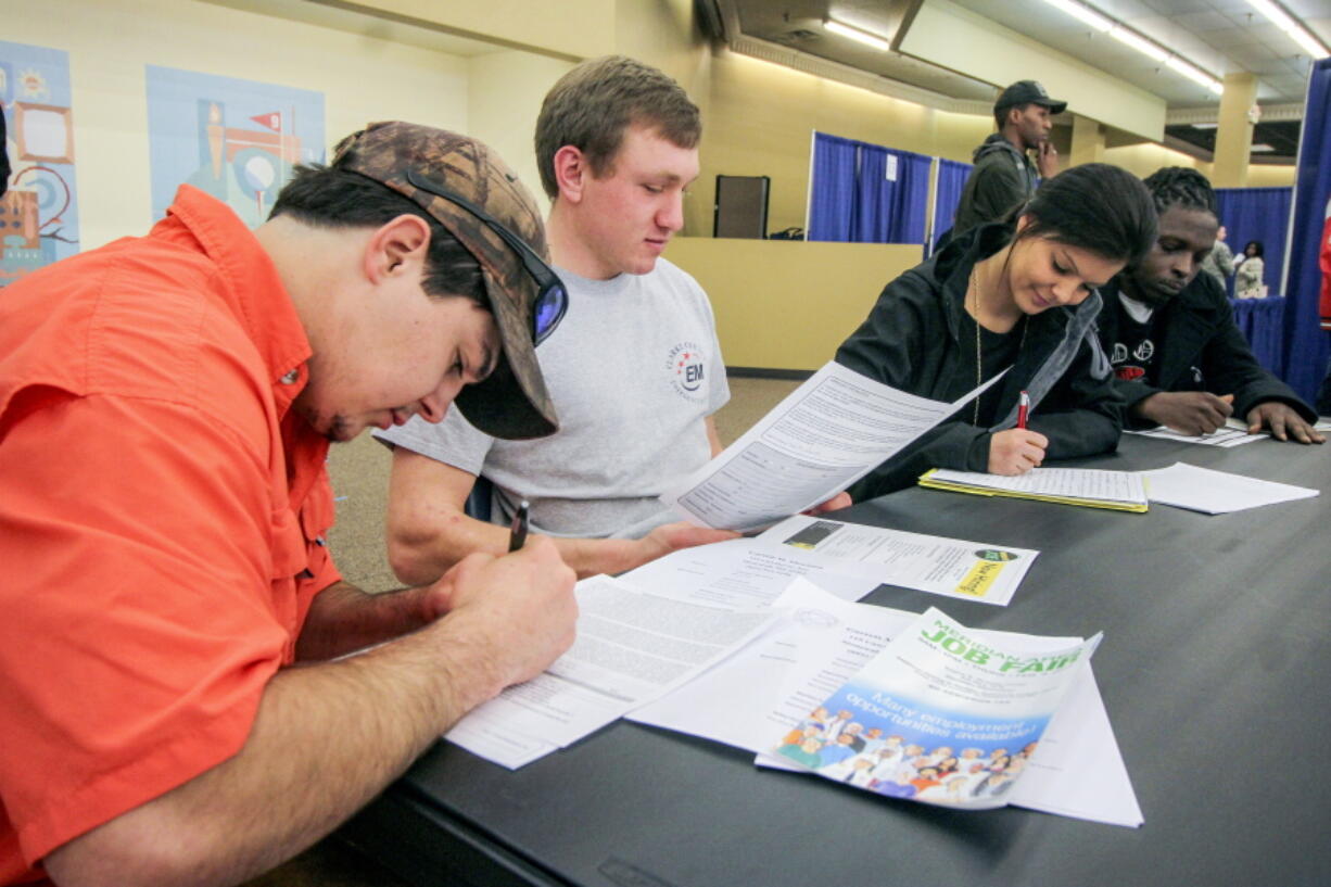 Garrett Thornton, left, Bradley Harper, Heather Wood and Marcus Brown fill out various job applications at the Governor’s Job Fair in the Tommy E. Dulaney Center in Meridian, Miss. On Tuesday, June 5, the Labor Department reports on job openings and labor turnover for April.