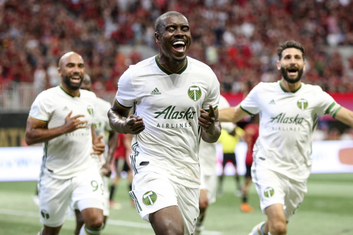 Portland Timbers defender Larrys Mabiala (33) celebrates a goal with forward Samuel Armenteros (99) and midfielder Diego Valeri (8) against Atlanta United in the first half of an MLS soccer match Sunday, June 24, 2018, in Atlanta, Ga.