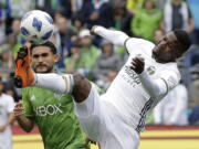 Portland Timbers midfielder Dairon Asprilla, right, kicks the ball in front of Seattle Sounders midfielder Cristian Roldan, left, during the first half of an MLS soccer match, Saturday, June 30, 2018, in Seattle. (AP Photo/Ted S.