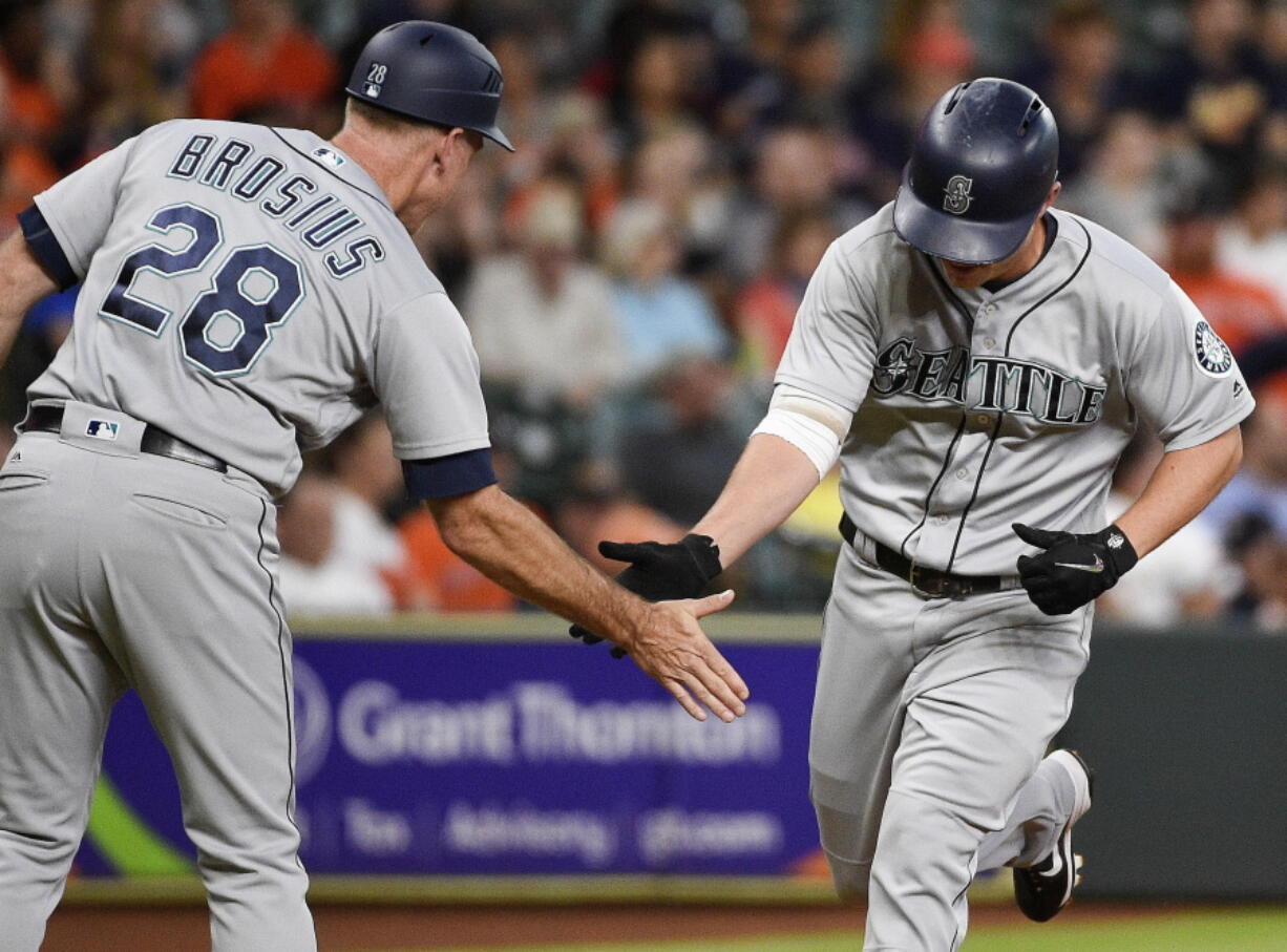 Seattle Mariners’ Kyle Seager, right, shakes hands with third base coach Scott Brosius after hitting a three-run home run off Astros starting pitcher Dallas Keuchel.