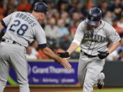 Seattle Mariners’ Kyle Seager, right, shakes hands with third base coach Scott Brosius after hitting a three-run home run off Astros starting pitcher Dallas Keuchel.