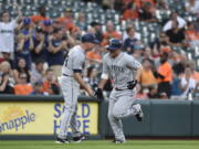 Seattle Mariners' Kyle Seager, right, is congratulated by third base coach Scott Brosius after hitting a solo home run during the fourth inning of baseball game Tuesday, June 26, 2018, in Baltimore.