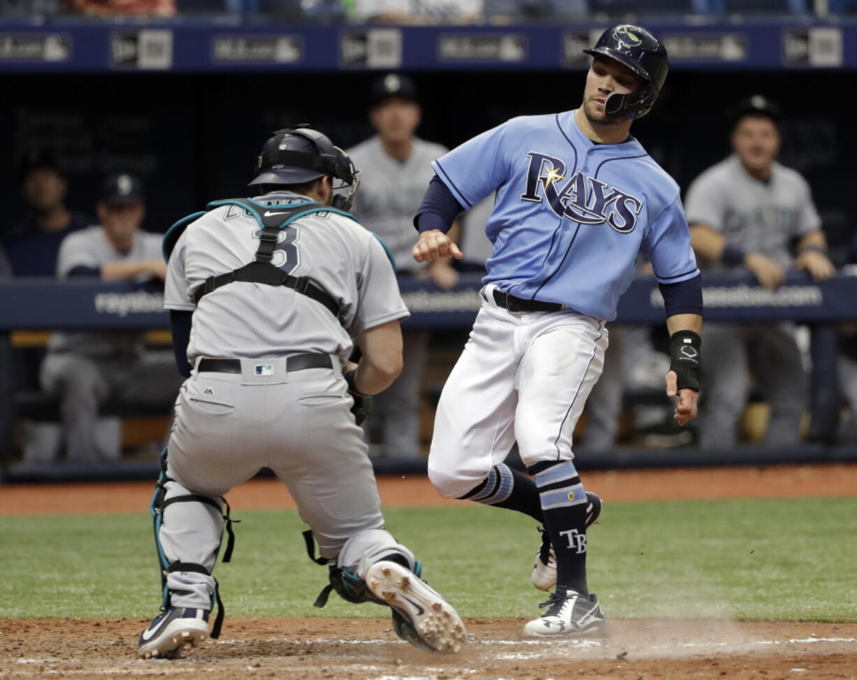 Seattle Mariners catcher Mike Zunino, left, tags out Tampa Bay Rays’ Johnny Field, right, as Field was trying to score on a single by Carlos Gomez during the ninth inning of a baseball game Sunday, June 10, 2018, in St. Petersburg, Fla.