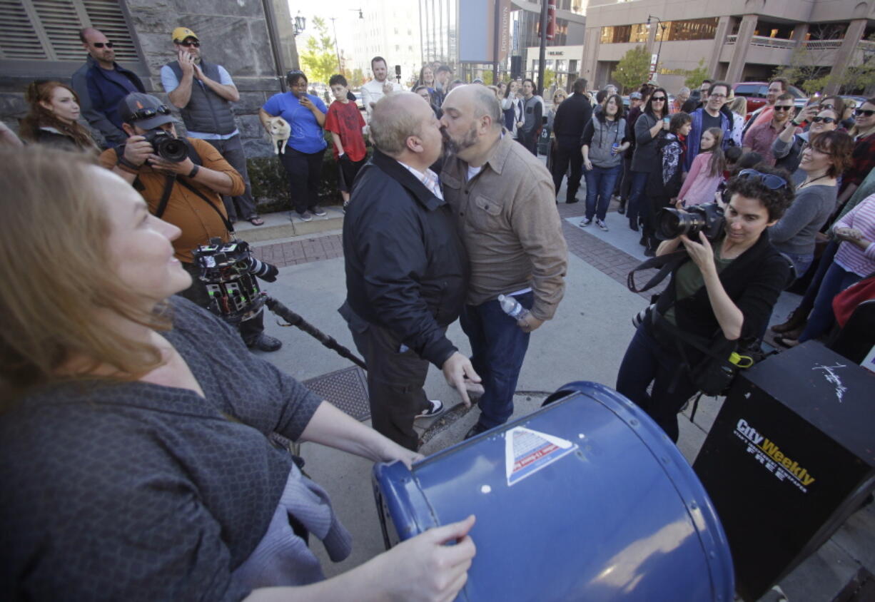 Mark Lindsay, left, and Tom Kerns kiss after mailing a resignation letter as Mormons gather for a mass resignation from the Church of Jesus Christ of Latter-day Saints, in Salt Lake City on Nov. 14, 2015.