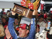 Clint Bowyer holds the Firekeepers Casino 400 trophy after winning a shortened NASCAR Cup Series auto race, Sunday, June 10, 2018, in Brooklyn, Mich.