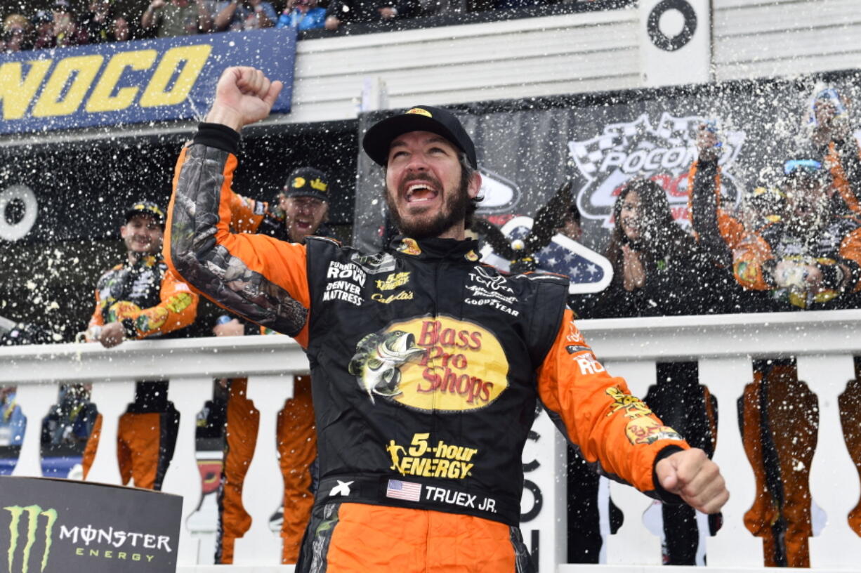 Martin Truex Jr. celebrates in Victory Lane after winning a NASCAR Cup Series auto race Sunday, June 3, 2018, in Long Pond, Pa.