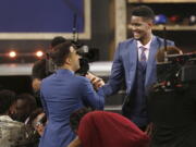 Arizona’s Deandre Ayton, right, is congratulated by friends and family after he was picked first overall by the Phoenix Suns during the NBA basketball draft in New York, Thursday, June 21, 2018.