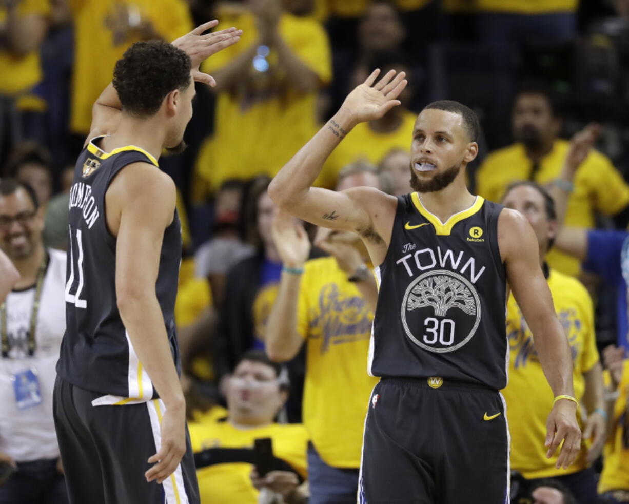 Golden State Warriors guard Stephen Curry (30) celebrates with guard Klay Thompson (11) during the second half of Game 2 of basketball’s NBA Finals in Oakland, Calif., Sunday, June 3, 2018.