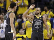 Golden State Warriors guard Stephen Curry (30) celebrates with guard Klay Thompson (11) during the second half of Game 2 of basketball’s NBA Finals in Oakland, Calif., Sunday, June 3, 2018.