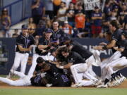 Washington players celebrate after beating the Cal State Fullerton in the 10th inning of an NCAA college baseball tournament super regional game in Fullerton, Calif., Sunday, June 10, 2018. Washington won, 6-5.