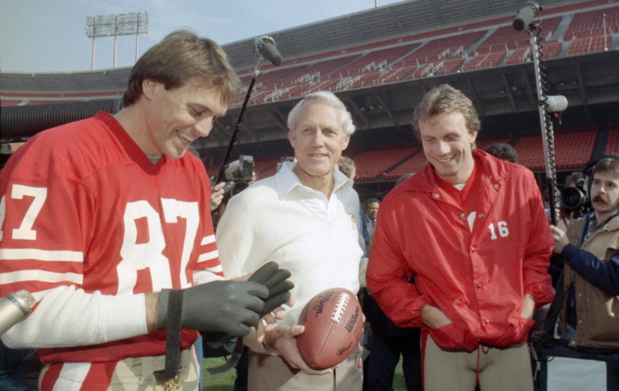 San Francisco 49ers’ head coach Bill Walsh, center, laughs with quarterback Joe Montana (16) and receiver Dwight Clark, left, at San Francisco’s Candlestick Park in this 1985 photo. Clark, the former 49ers wide receiver whose reception known as “The Catch” sent San Francisco to its first Super Bowl, has died one year after revealing he had ALS. He was 61. The team said Clark died Monday, June 4, 2018, surrounded by friends and family.