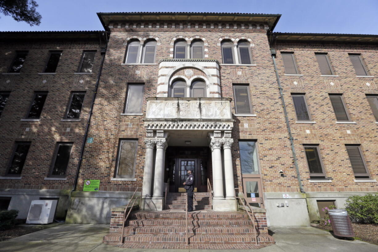 A security officer stands on steps at the entrance to Western State Hospital on April 11, 2017, in Lakewood. Washington state’s largest psychiatric hospital has lost its federal certification and $53 million in federal funds after failing to achieve basic health and safety standards.