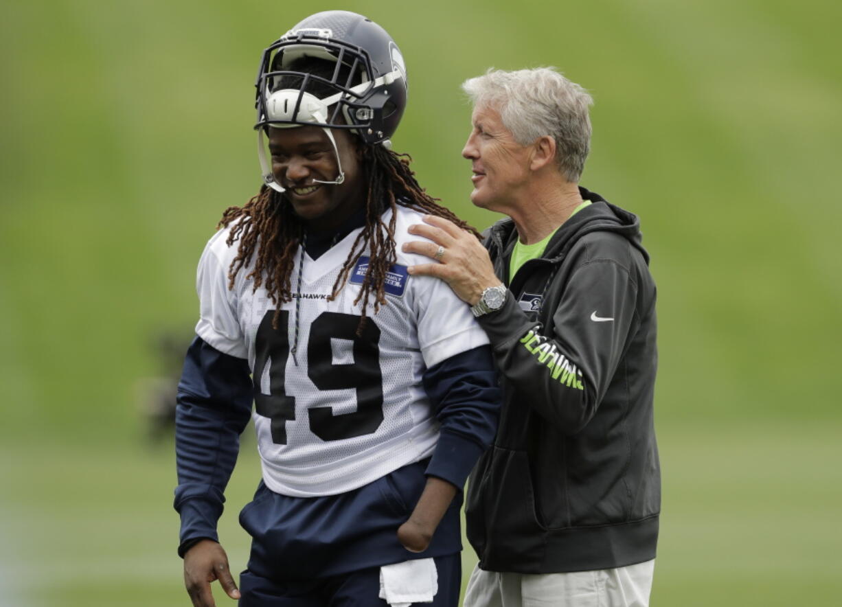 Seattle Seahawks head coach Pete Carroll, right, talks with linebacker Shaquem Griffin following NFL football practice, Thursday, June 14, 2018, in Renton, Wash. (AP Photo/Ted S.