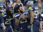 FILE - In this Aug. 25, 2017, file photo, Seattle Seahawks cornerback Richard Sherman, free safety Earl Thomas, center, and middle linebacker Bobby Wagner (54) react on the sideline during the second half of an NFL football preseason game against the Kansas City Chiefs, in Seattle. Thomas is putting the pressure on the Seattle Seahawks for a new contract, saying he will not participate in any team activities until his contract situation is resolved. That includes the upcoming mandatory minicamp.