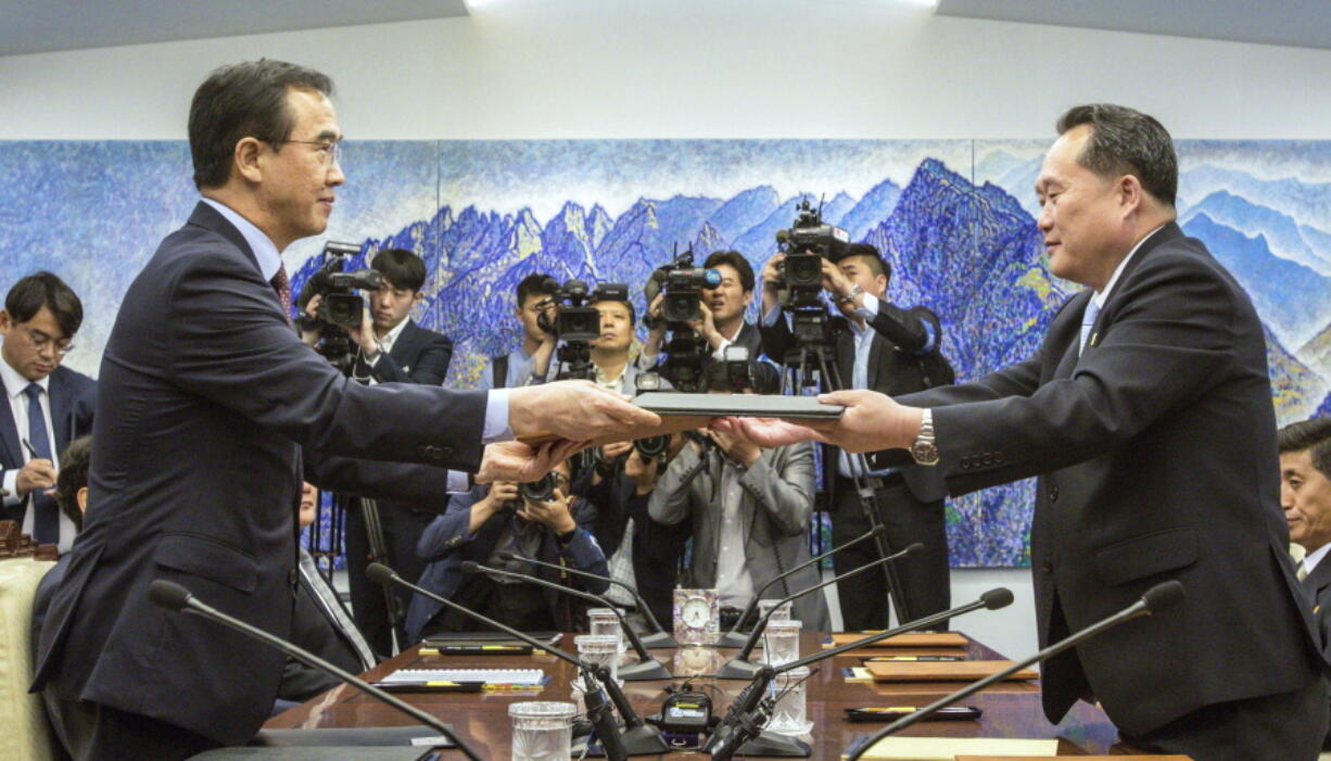 South Korean Unification Minister Cho Myoung-gyon, left, and North Korean delegation head Ri Son Gwon exchange documents signed an agreement during their meeting inside the Peace House at the southern side of Panmunjom in the Demilitarized Zone Friday, June 1, 2018. North and South Korea on Friday resumed senior-level peace talks Seoul sees as an important step in building trust with Pyongyang amid a U.S.-led diplomatic push to persuade the North to give up its nuclear weapons.