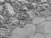 The New Horizons spacecraft photographed dunes, small ripples at bottom right, on Pluto’s Sputnik Planitia ice plain. At upper left are a series of mountains.