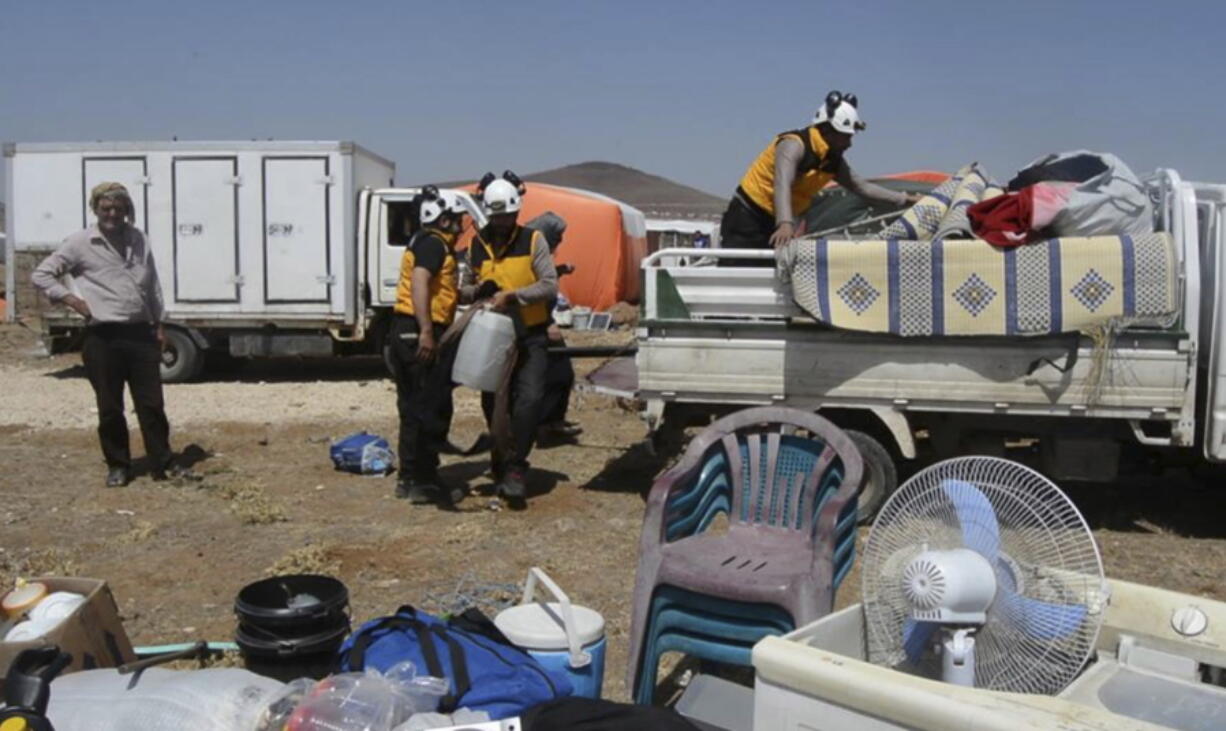 Civil defense workers help civilians who fled from Daraa after shelling by Syrian government forces, in the town of Qunaitra, near Israeli-occupied Golan Heights, southern Syria, Thursday, June 28, 2018. A barrage of airstrikes hit rebel-held areas in southwestern Syria on Thursday, killing civilians hiding in an underground shelter as government forces pressed their offensive to reclaim a region that was until recently part of a U.S.-backed and negotiated truce.