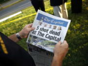 Steve Schuh, county executive of Anne Arundel County, holds a copy of The Capital Gazette near the scene of a shooting at the newspaper's office June 29 in Annapolis, Md. A man armed with smoke grenades and a shotgun attacked journalists in the building June 28 killing five people before police quickly stormed the building and arrested him, police and witnesses said.