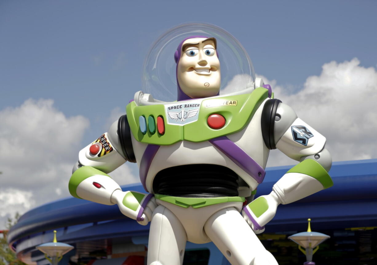 In this Saturday, June 23, 2018 photo, Buzz Lightyear stands near the entrance to the Aliens Swirling Saucers ride at Toy Story Land in Disney’s Hollywood Studios at Walt Disney World in Lake Buena Vista, Fla.