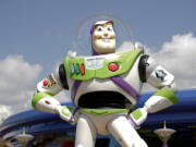 In this Saturday, June 23, 2018 photo, Buzz Lightyear stands near the entrance to the Aliens Swirling Saucers ride at Toy Story Land in Disney’s Hollywood Studios at Walt Disney World in Lake Buena Vista, Fla.