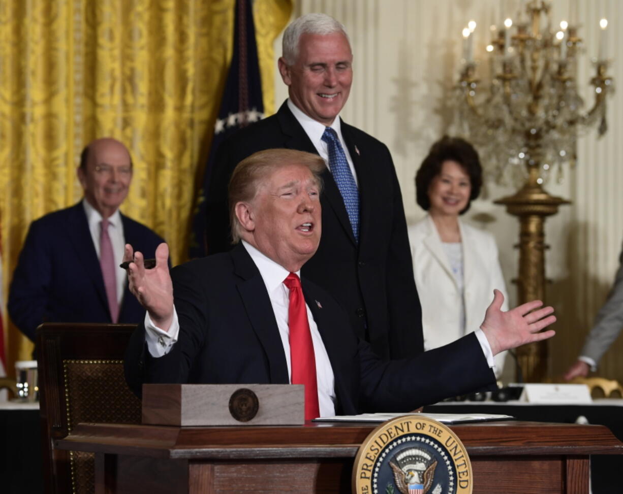 President Donald Trump gestures as he signs a “Space Policy Directive” during a meeting of the National Space Council in the East Room of the White House on Monday in Washington, as Vice President Mike Pence watches.