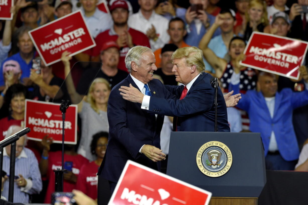 President Donald Trump greets Gov. Henry McMaster during a rally to show support for the governor at Airport High School on Monday in West Columbia, S.C.