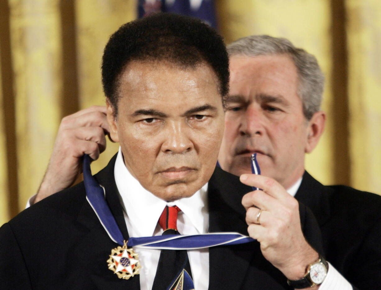 FILE - In this Nov. 2009 file photo, President Bush presents the Presidential Medal of Freedom to boxer Muhammad Ali in the East Room of the White House. President Donald Trump said he is thinking “very seriously” about pardoning Muhammad Ali, even though the Supreme Court vacated the boxing champion’s conviction in 1971.