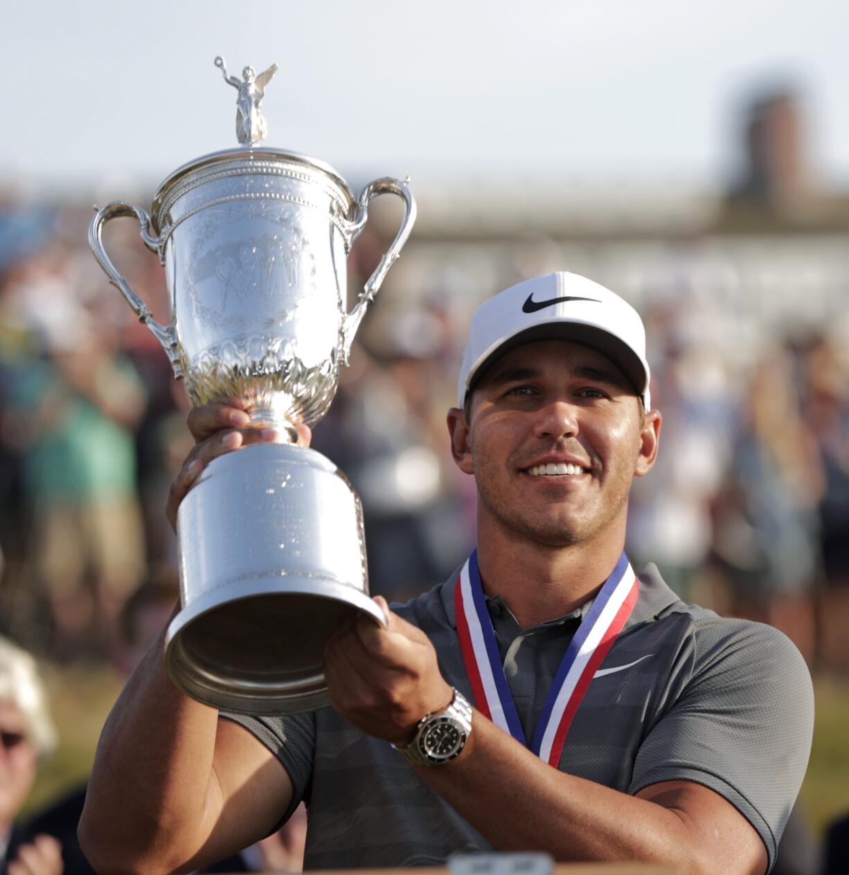 Brooks Koepka holds up the Golf Champion Trophy after winning the U.S. Open Golf Championship, Sunday, June 17, 2018, in Southampton, N.Y.